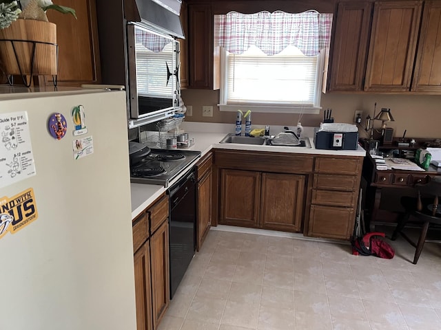 kitchen with white refrigerator, range, light tile patterned flooring, and sink