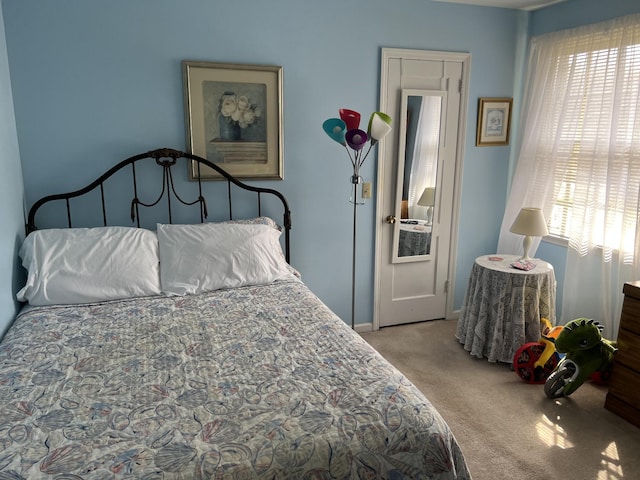 bedroom featuring light carpet and multiple windows