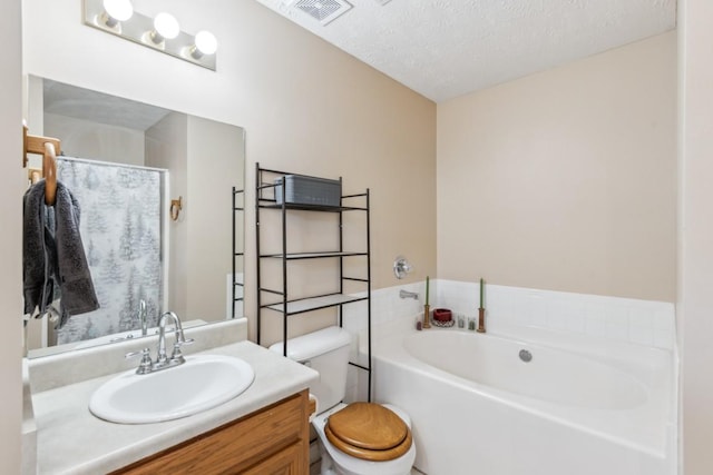 bathroom with vanity, a tub to relax in, a textured ceiling, and toilet