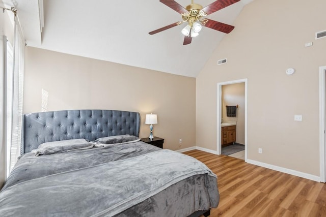 bedroom with connected bathroom, light hardwood / wood-style flooring, high vaulted ceiling, and ceiling fan