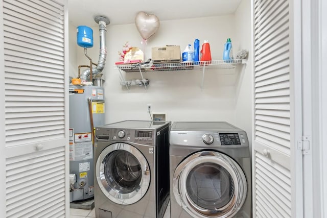 washroom featuring light tile patterned flooring, separate washer and dryer, and water heater