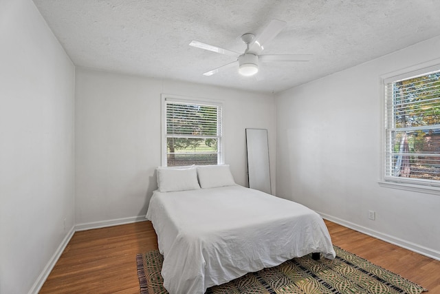 bedroom featuring hardwood / wood-style flooring, a textured ceiling, and ceiling fan