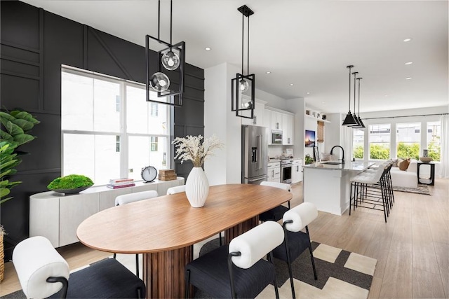 dining space featuring sink and light wood-type flooring