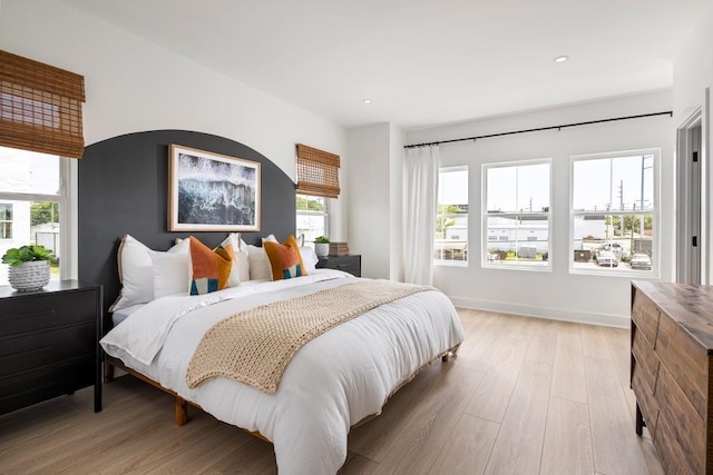 bedroom featuring multiple windows and light hardwood / wood-style flooring