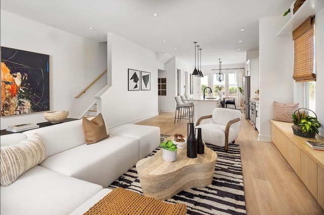 living room with sink and light hardwood / wood-style flooring