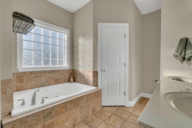 full bath featuring tile patterned flooring, a sink, baseboards, and a bath