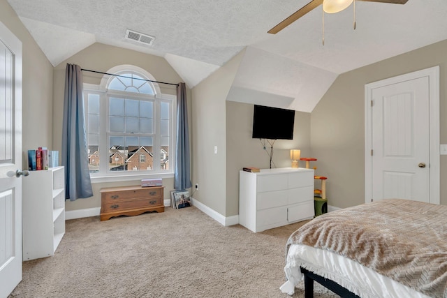 bedroom featuring light carpet, baseboards, visible vents, lofted ceiling, and a textured ceiling