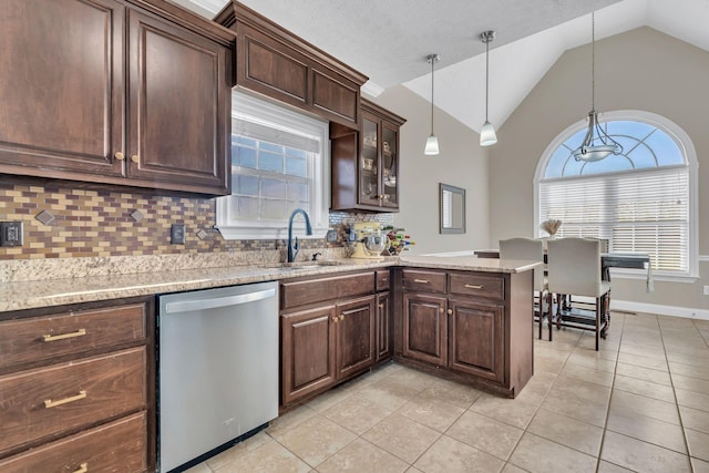 kitchen with a peninsula, a sink, hanging light fixtures, dishwasher, and glass insert cabinets