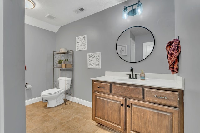 half bathroom with visible vents, toilet, vanity, tile patterned flooring, and baseboards