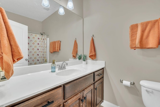 bathroom with toilet, curtained shower, vanity, and baseboards