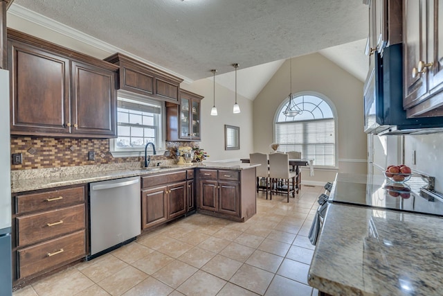 kitchen with light stone counters, glass insert cabinets, hanging light fixtures, stainless steel appliances, and a sink