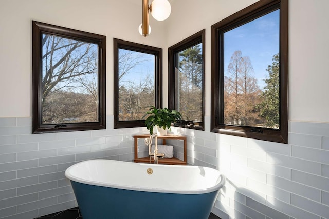 bathroom featuring a bath and tile walls