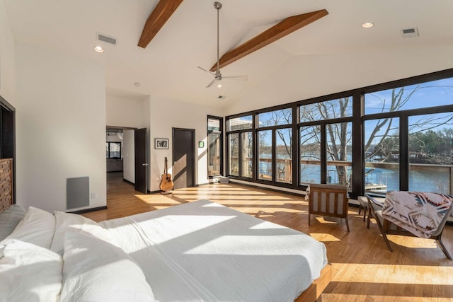 bedroom with a water view, light wood-type flooring, high vaulted ceiling, and beam ceiling