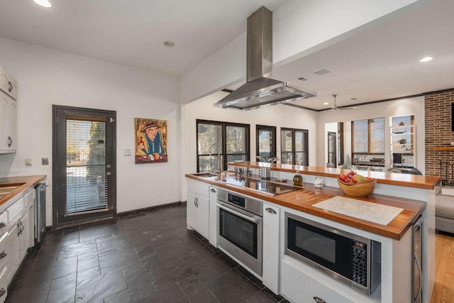 kitchen featuring white cabinetry, appliances with stainless steel finishes, wooden counters, and island exhaust hood