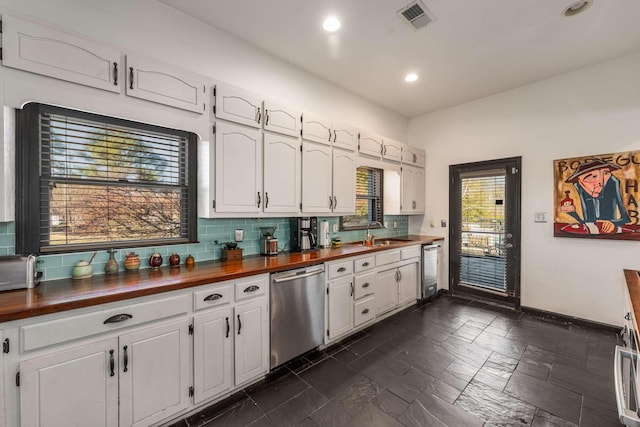 kitchen with dishwasher, sink, white cabinets, and butcher block countertops