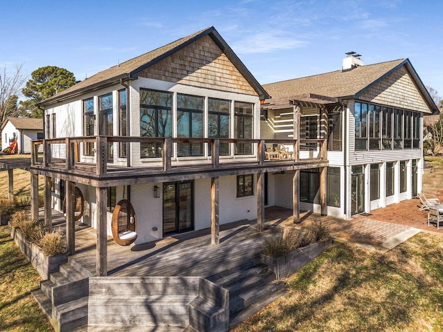 rear view of property featuring a pergola, a deck, and a sunroom