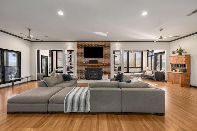 living room with crown molding, ceiling fan, and light hardwood / wood-style flooring