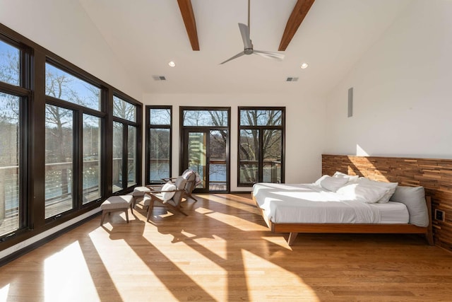 bedroom featuring multiple windows, ceiling fan, a towering ceiling, and beam ceiling