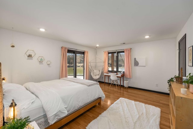 bedroom with access to exterior and light wood-type flooring