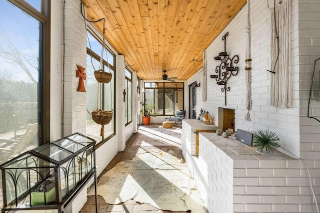 sunroom / solarium with a wealth of natural light, wooden ceiling, and ceiling fan