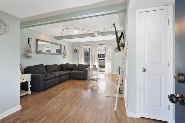 living room with beamed ceiling and wood-type flooring