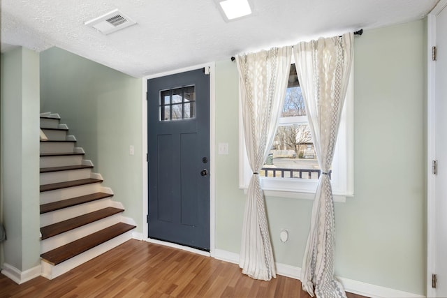 entrance foyer with wood-type flooring and a textured ceiling