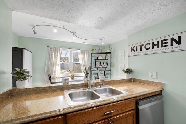 kitchen featuring sink, stainless steel dishwasher, and a textured ceiling