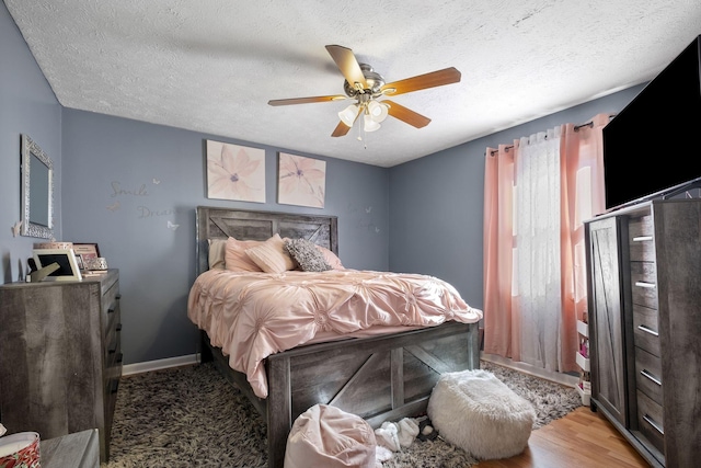 bedroom featuring a textured ceiling, ceiling fan, and light hardwood / wood-style floors