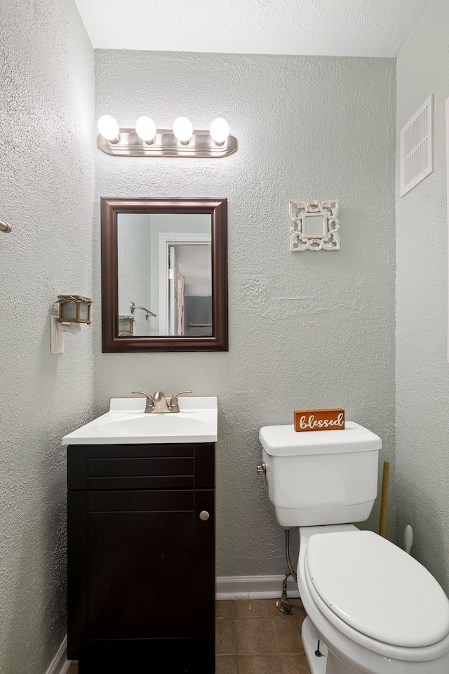 bathroom featuring tile patterned flooring, vanity, and toilet