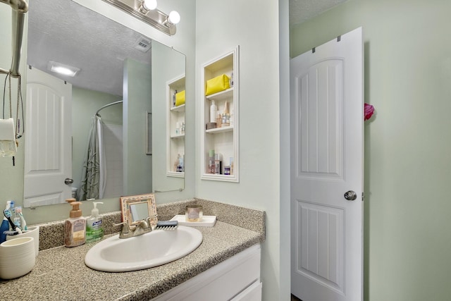 bathroom featuring vanity, a textured ceiling, and a shower with shower curtain