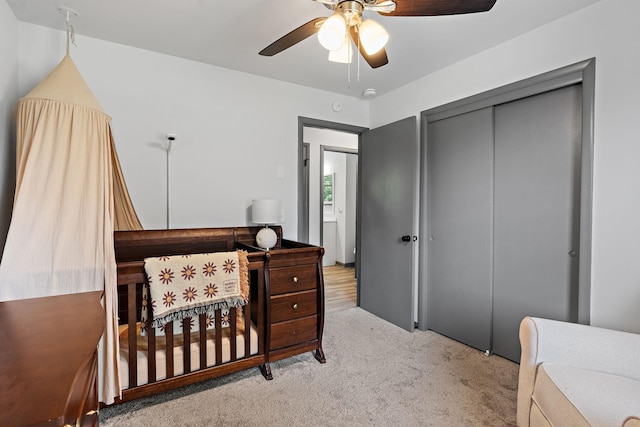 carpeted bedroom with ceiling fan and a closet