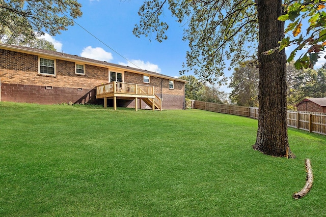 back of property with a wooden deck and a lawn