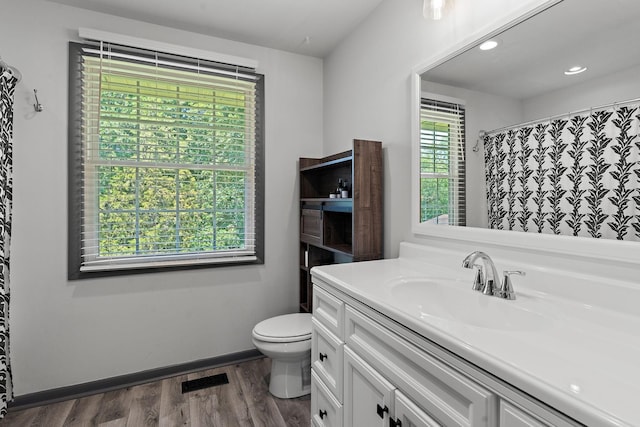 bathroom with walk in shower, vanity, toilet, and hardwood / wood-style floors