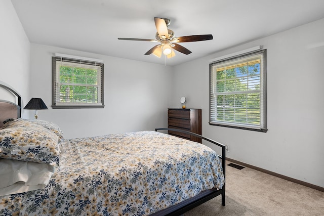 carpeted bedroom with ceiling fan and multiple windows