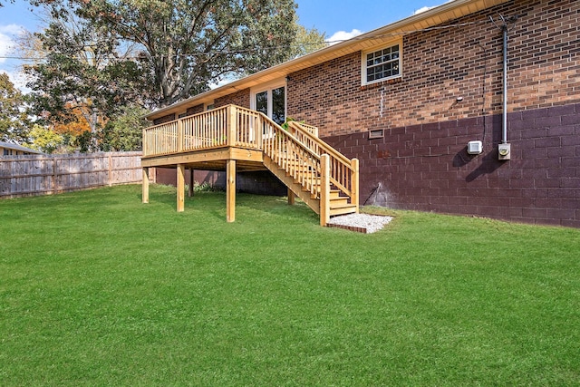 rear view of house featuring a wooden deck and a yard