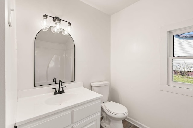 bathroom with vanity, toilet, and hardwood / wood-style floors