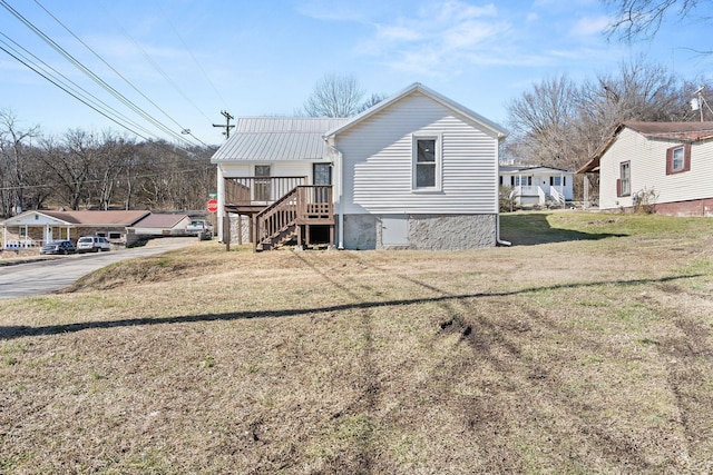 rear view of house featuring a deck and a lawn