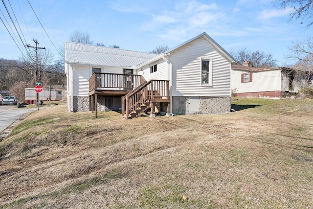 rear view of house with a wooden deck and a yard