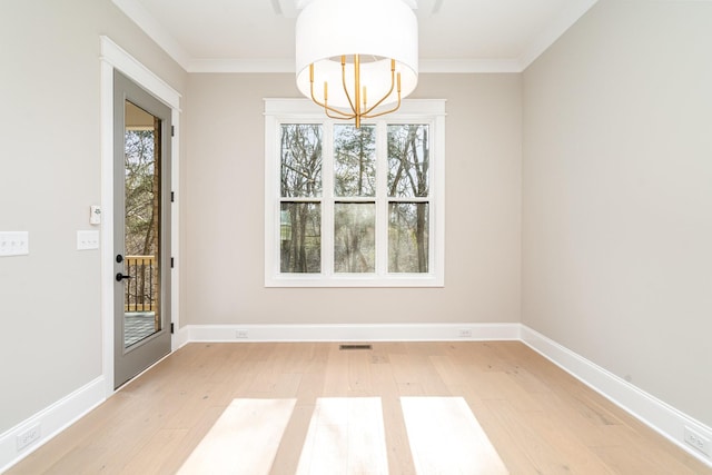 unfurnished dining area with an inviting chandelier, wood-type flooring, ornamental molding, and a healthy amount of sunlight