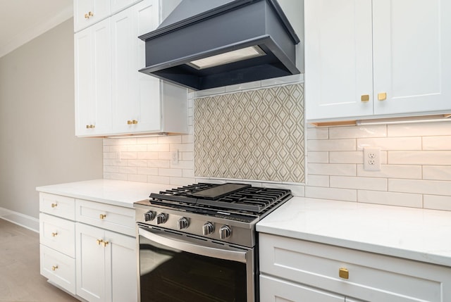 kitchen with premium range hood, white cabinetry, light wood-type flooring, stainless steel range with gas stovetop, and decorative backsplash