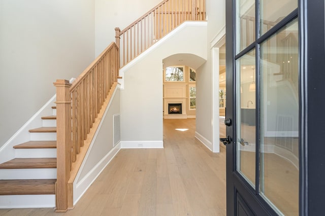 stairs featuring hardwood / wood-style flooring and a high ceiling