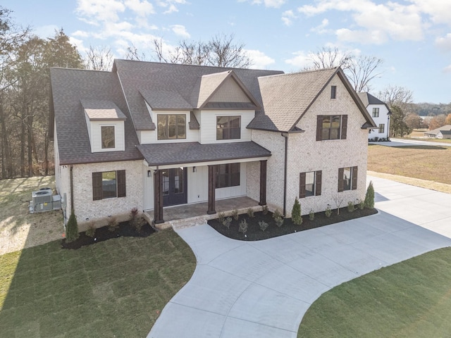 view of front facade featuring central AC unit, a front lawn, and a porch