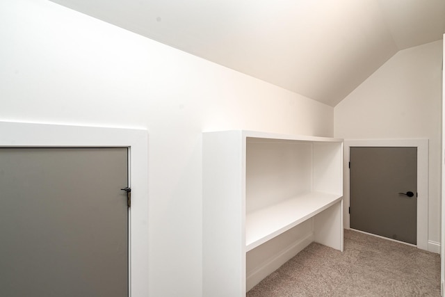 spacious closet with light carpet and vaulted ceiling