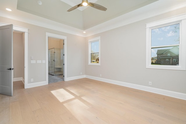 unfurnished bedroom featuring multiple windows, ensuite bath, ceiling fan, and light wood-type flooring