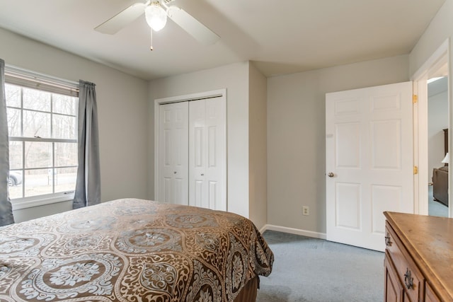 bedroom with ceiling fan, light carpet, and a closet