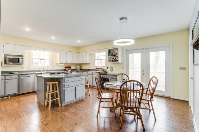 kitchen with a kitchen island, gray cabinetry, stainless steel appliances, french doors, and wood-type flooring