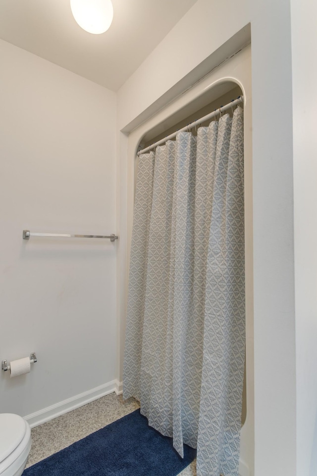 bathroom with toilet and curtained shower