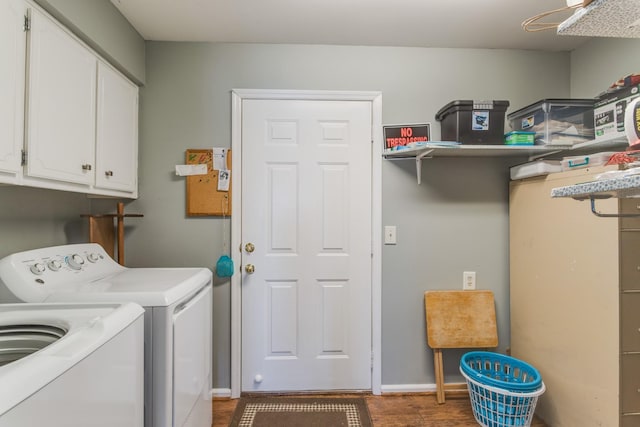 laundry area featuring washer and dryer, baseboards, cabinet space, and wood finished floors