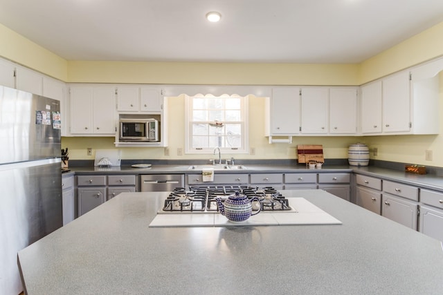 kitchen featuring white cabinetry, sink, gray cabinets, and stainless steel appliances