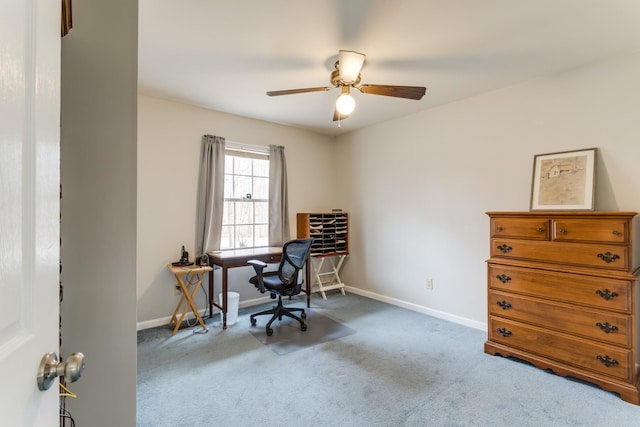 carpeted office featuring baseboards and a ceiling fan